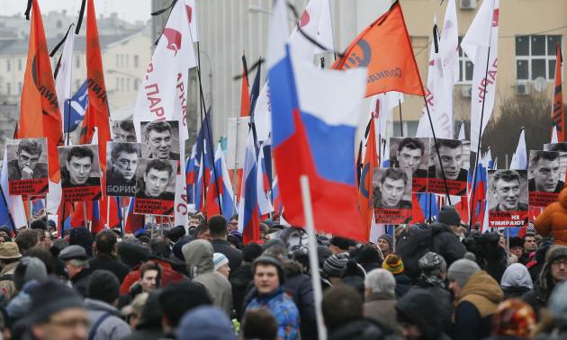 People hold flags and posters during march to commemorate Kremlin critic Nemtsov in central Moscow