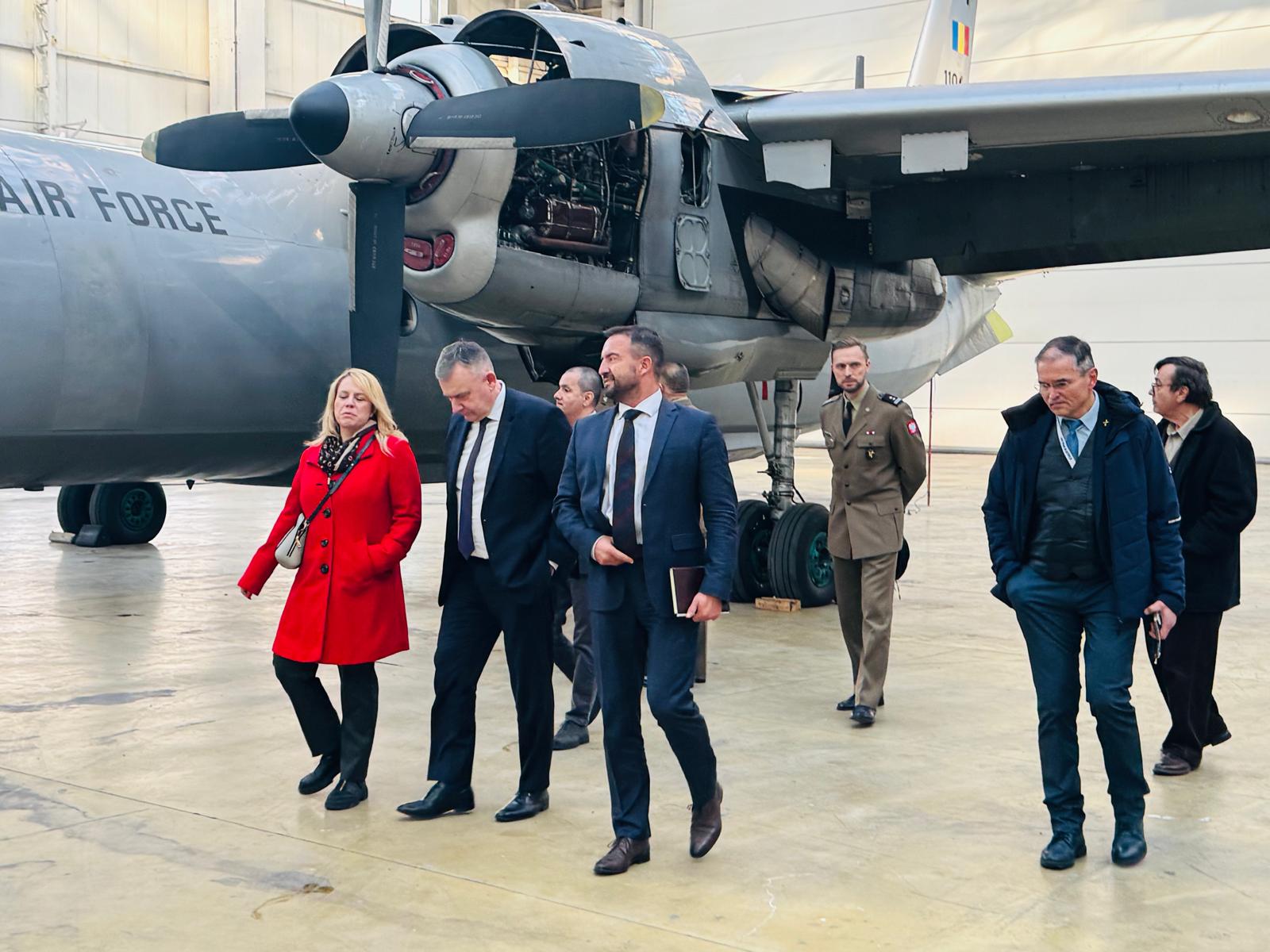 Delegatie oficială în hangarul ROMAERO, inspectând un avion al Forțelor Aeriene Române.